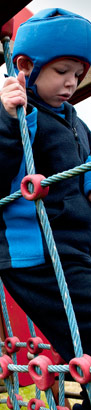 boy in helmet on climbing apparatus