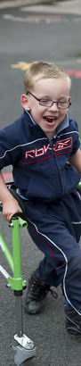 A young boy uses a walking frame
to move across a playground