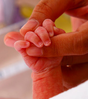 A mother and baby hold
hands