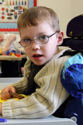 A boy sits before a tray of food items and
turns to the camera