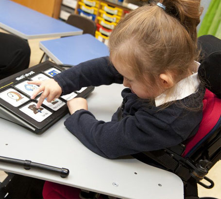 A girl wearing head protection reaches toward
                  one of several cards on a table