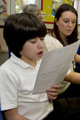 A girl with her teacher in front of a
                  computer