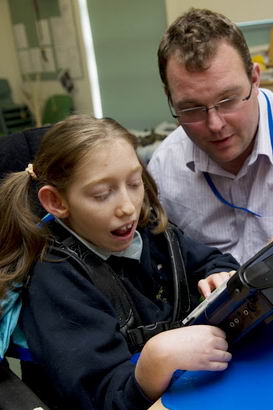 A girl uses a communication device
with her teacher