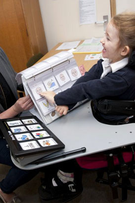 A girl and her teacher look at a selection
of cards on a table