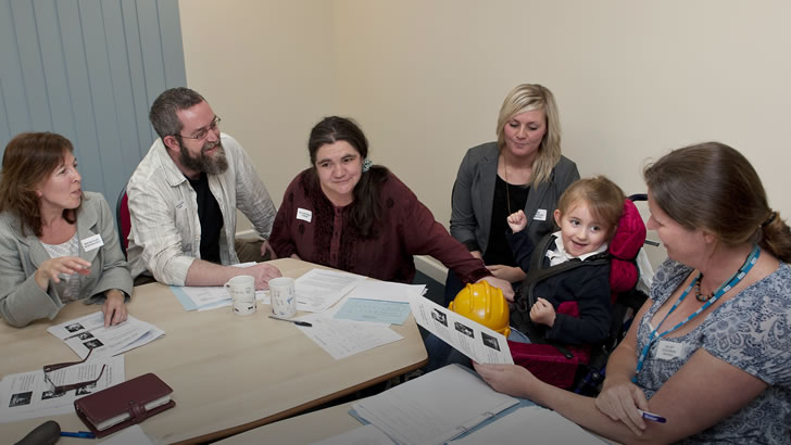 A girl with her parents,
teachers and carers take part in a review meeting
