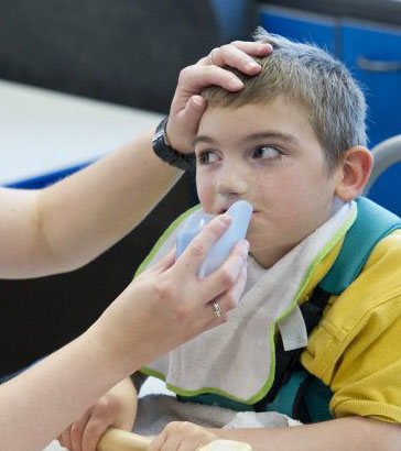 role-play: boy in hospital bed being fed
                  with a spoon