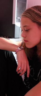 a teenage girl looks pensive as she sits
at the desk in her bedroom