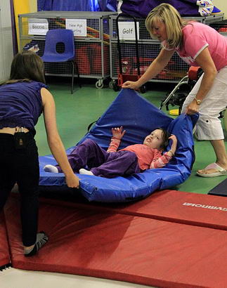 Staff moving pupil on mat