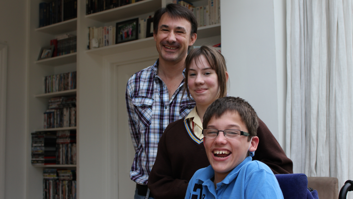 A portrait of a father and
his son and daughter smiling