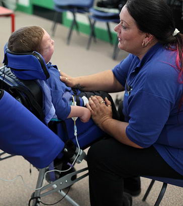 Boy in chair with carer