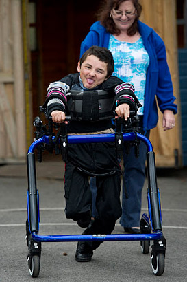 Boy with walking support and carer