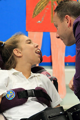 Girl in wheelchair interacting with carer