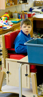 Seated boy looks across classroom.