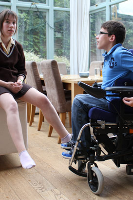 A girl with her brother in a wheelchair