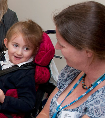 A child smiling at a practitioner
                  during a review meeting