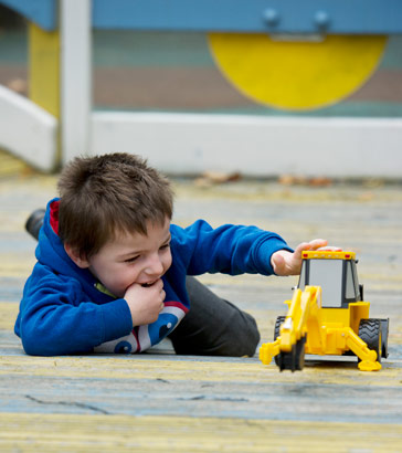 Boy playing with a toy digger