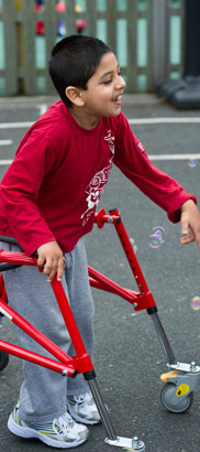 Boy with walking aid and bubbles