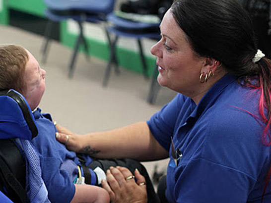 Boy in chair with carer