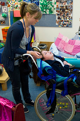 Child in wheelchair with two carers
