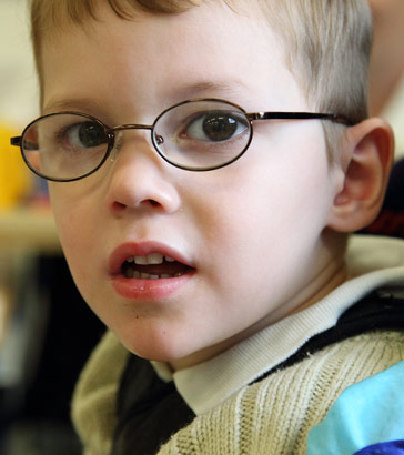 A portrait of a boy wearing glasses