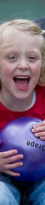 Happy young girl in pram with
                  ball