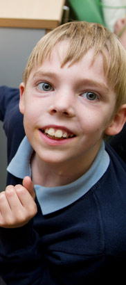 a boy smiles at the computer