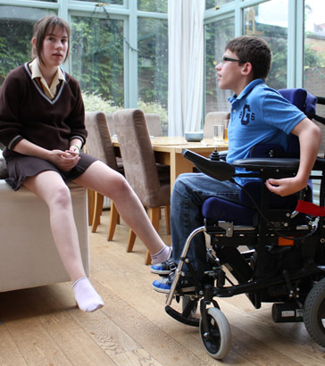 Brother in automated wheelchair talks to his
sister in the conservatory of their family home