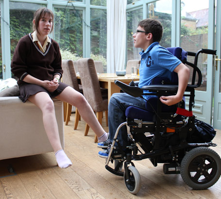 Brother in automated wheelchair talks to his
sister in the conservatory of their family home