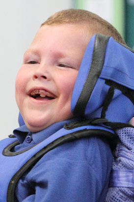 Teacher and boy in wheelchair smiling
at each other