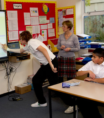 A boy using a touchscreen during
                  an English lesson