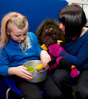 A girl and her teacher witha puppet