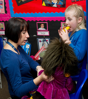 A girl and her teacher with a puppet