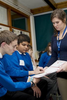 A boy attaches stickers to a
                  self-assessment form