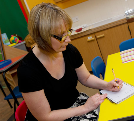 A teacher writes in a small pad
of paper