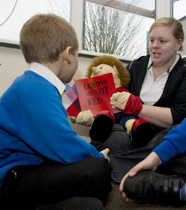 Teacher reading a book to children