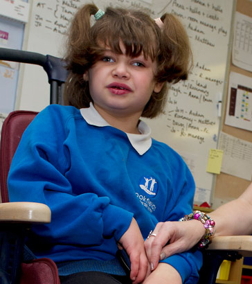 A girl in a specialist chair and
a teaching assistant