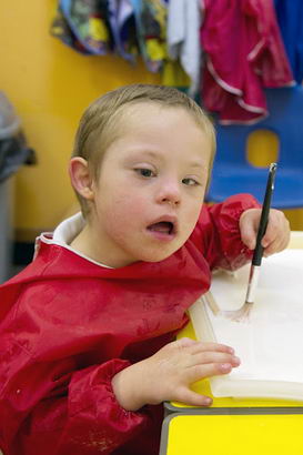 A boy holds a brush