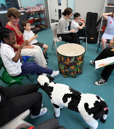 teachers and students seated around different
                  objects