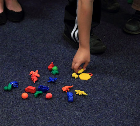 Child picking up a toy from the floor