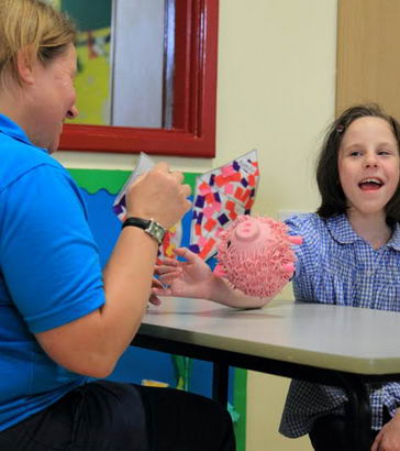 girl with carer interacting at a table