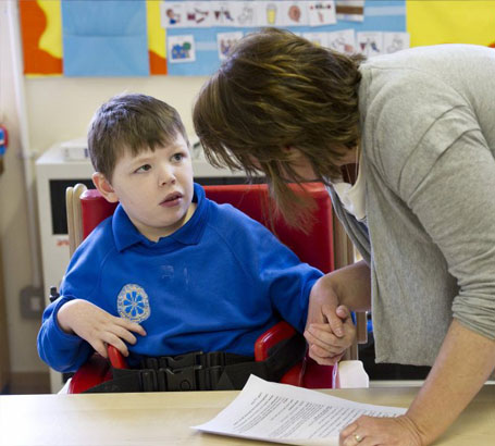 Teacher helping a boy with a task