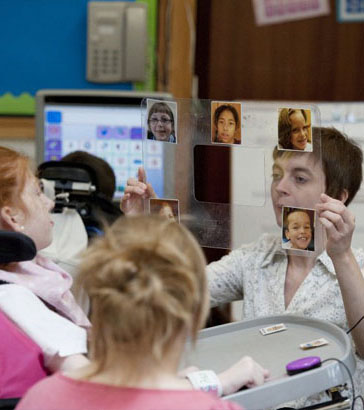 A boy holding up a board with activity
cards on it