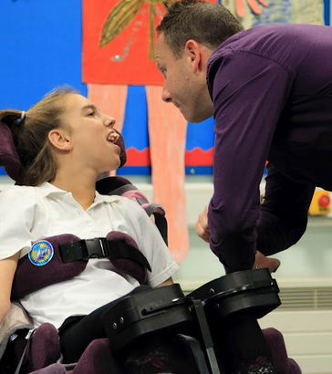 A male teacher and a teenage girl interact
in the classroom