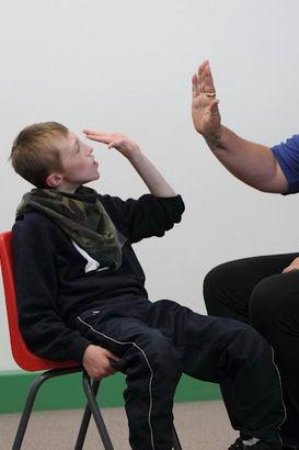 A female teacher and a teenage boy high
                  five each other