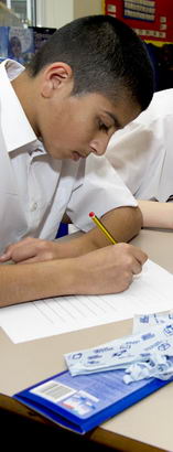 Three teenage boys take part in
a more traditional learning setting – taking a formal test in their classroom