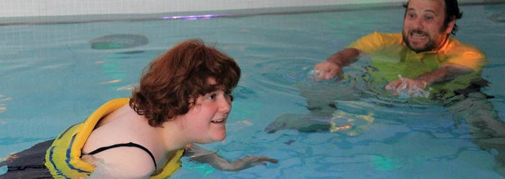 A teenage girl and a male teacher use
intensive interaction techniques in a swimming pool