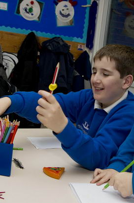 Two boys at desk with adult