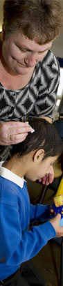 A teacher holds the hand of a deaf boy