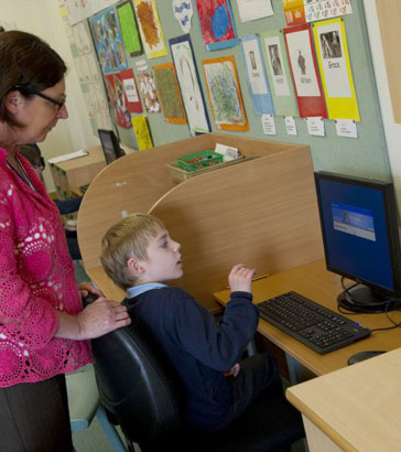 Female adult and boy at computer