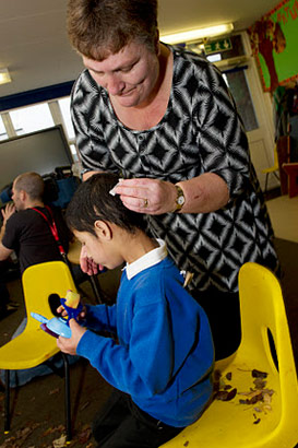 Teacher engages with a hearing-impaired
                  boy